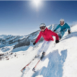 deux personnes qui descendent une piste de ski